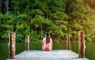 persona reflexionando sola frente a un lago. Foto coaching